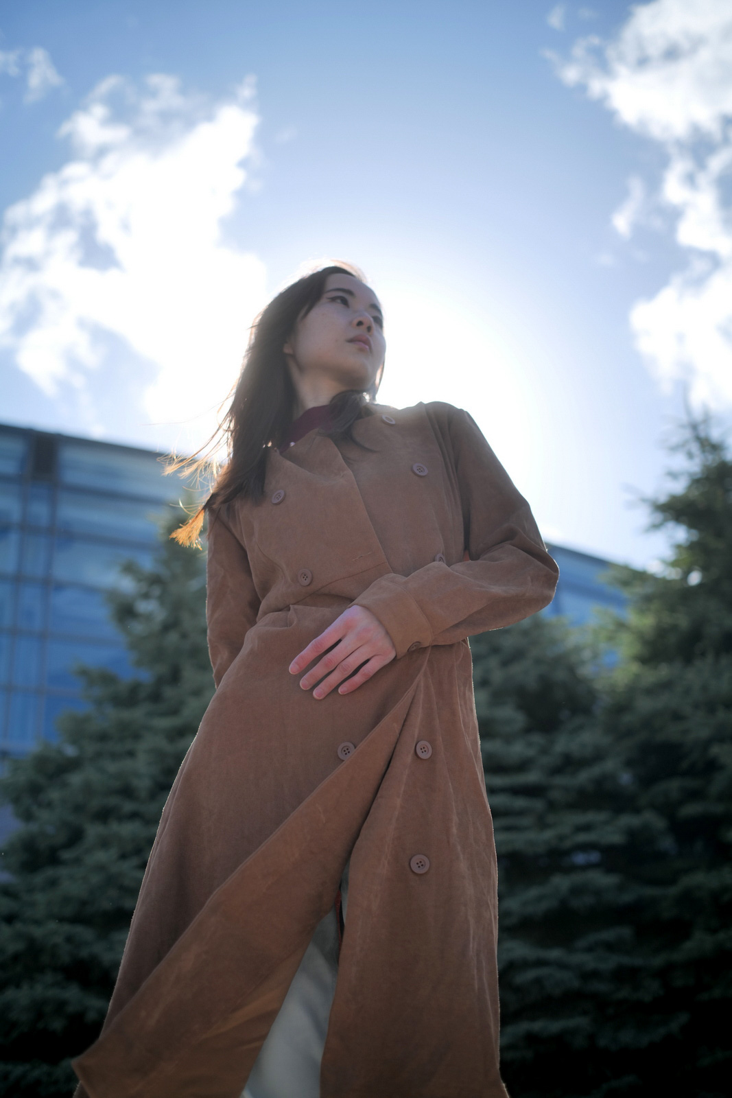 青空を背景に下から見上げた女性モデル・クレアのポートレート